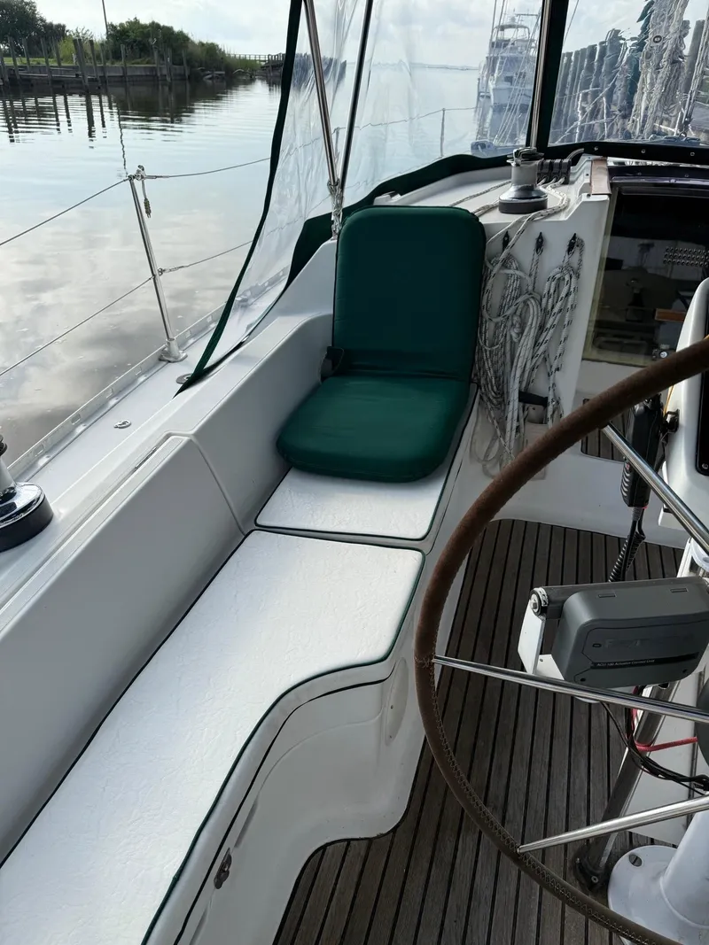 Slide: The Image of Cockpit of 2000 Jeanneau Sun Odyssey 36.2 sailboat with green cushion and wooden steering wheel. - 12