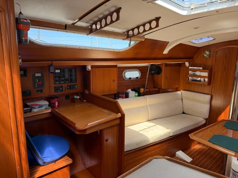 Slide: The Image of Interior of 2000 Jeanneau Sun Odyssey 36.2 sailboat with wooden furnishings and cozy seating area. - 22