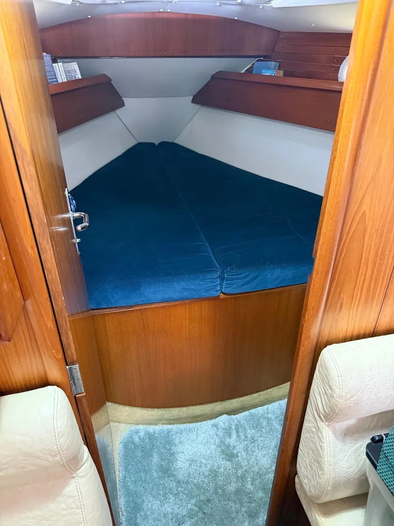 Slide: The Image of Cozy cabin interior of 2000 Jeanneau Sun Odyssey 36.2 sailboat with blue bedding. - 26