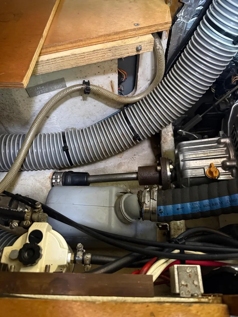 Slide: The Image of Engine compartment of a 2000 Jeanneau Sun Odyssey 36.2 sailboat, showing hoses and mechanical components. - 34