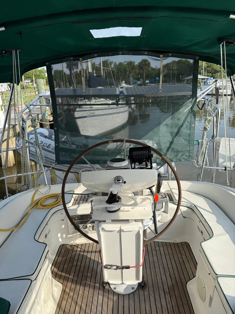 Slide: The Image of Cockpit of 2000 Jeanneau Sun Odyssey 36.2 sailboat with green canopy and wooden deck. - 6