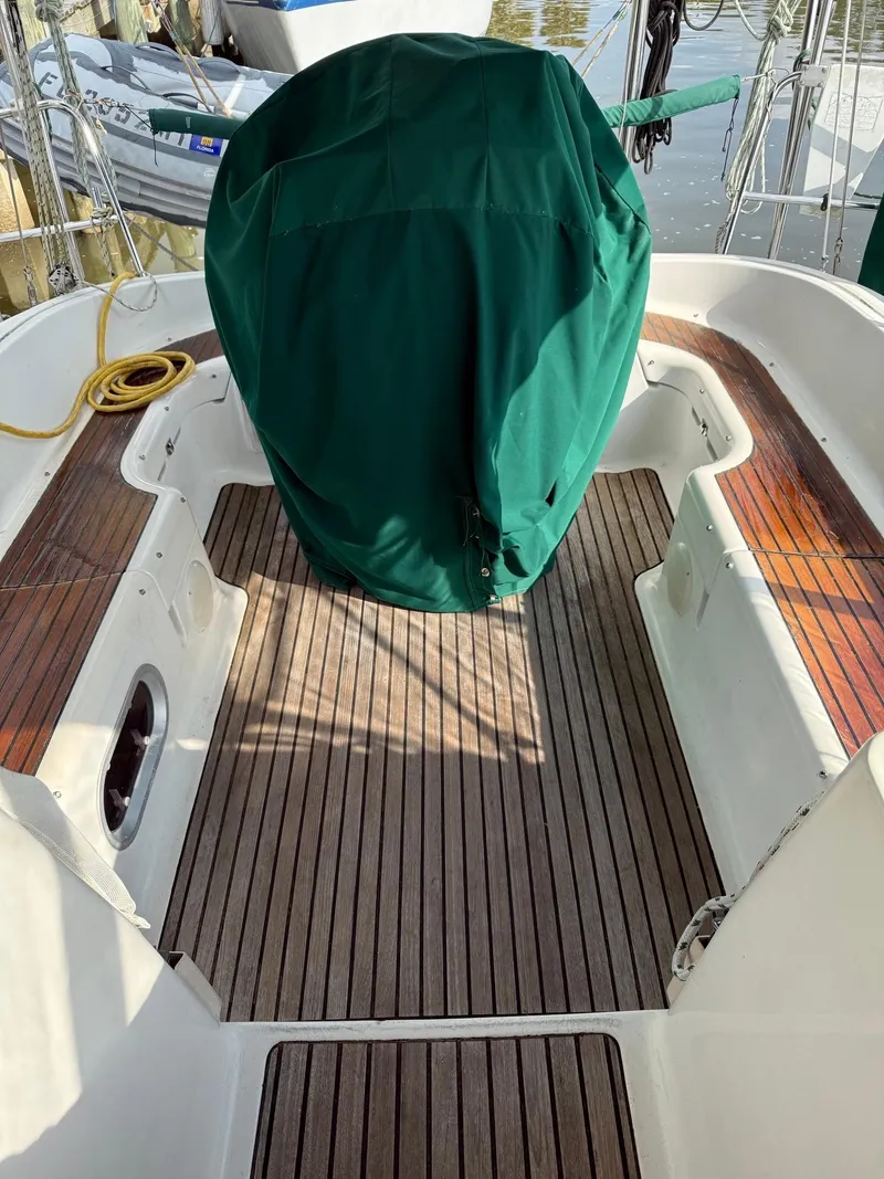 Slide: The Image of Jeanneau Sun Odyssey 36.2 cockpit with green cover, teak flooring, and moored setting. - 7