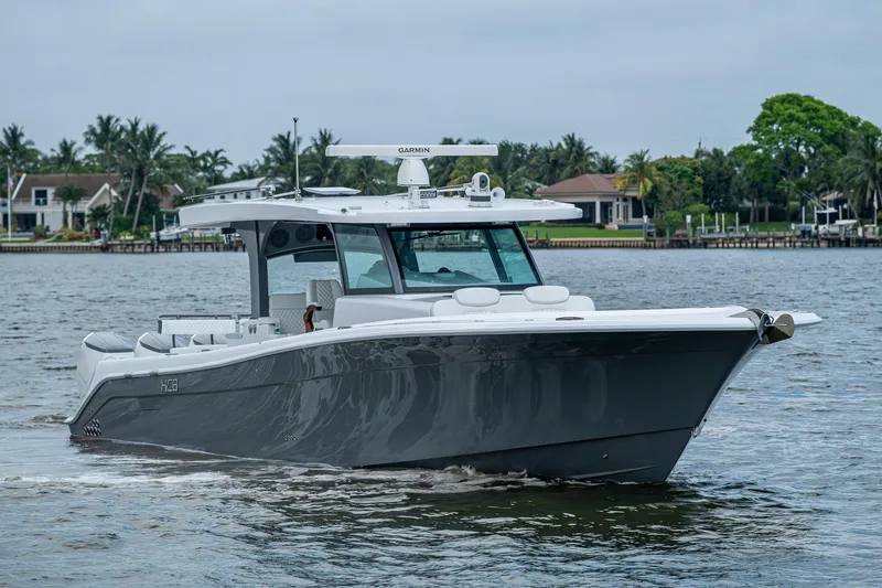 The Image of 2025 HCB 48 Campeon boat cruising on a calm waterway, surrounded by lush greenery. - 0