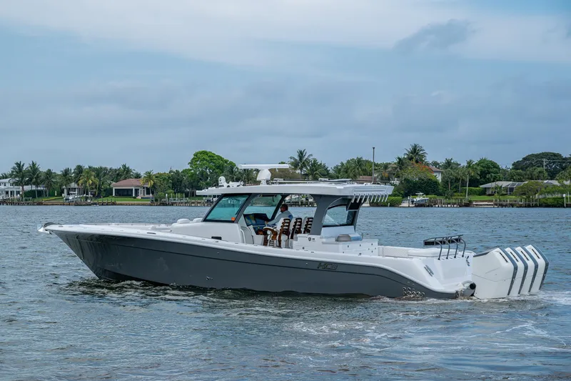 Slide: The Image of 2025 HCB 48 Campeon boat cruising on a calm waterway with a scenic backdrop. - 10