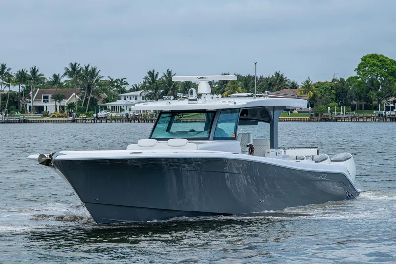 Slide: The Image of 2025 HCB 48 Campeon boat cruising on a calm waterway with palm trees in the background. - 3