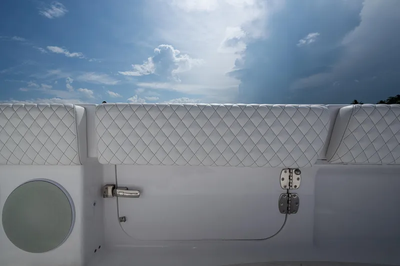 Slide: The Image of 2025 HCB 48 Campeon boat interior with quilted upholstery and speaker under a cloudy sky. - 40