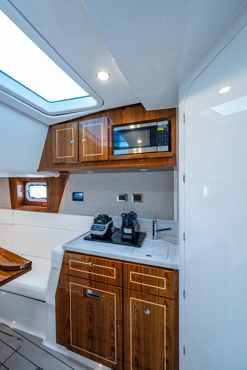 Slide: The Image of Interior of 2025 HCB 48 Campeon yacht with modern kitchenette and wooden cabinetry. - 47