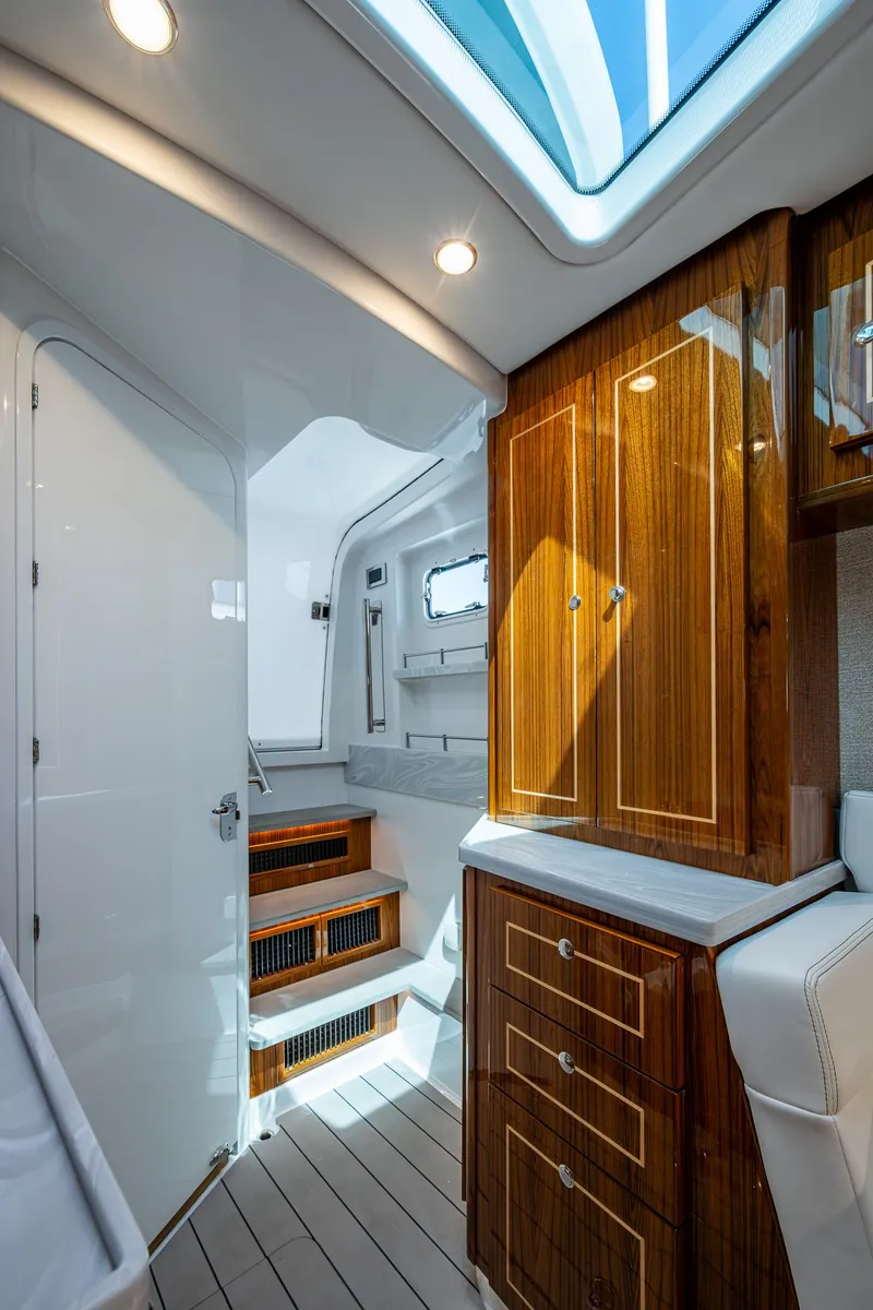 Slide: The Image of Luxurious interior of 2025 HCB 48 Campeon boat with wood cabinetry and skylight. - 49