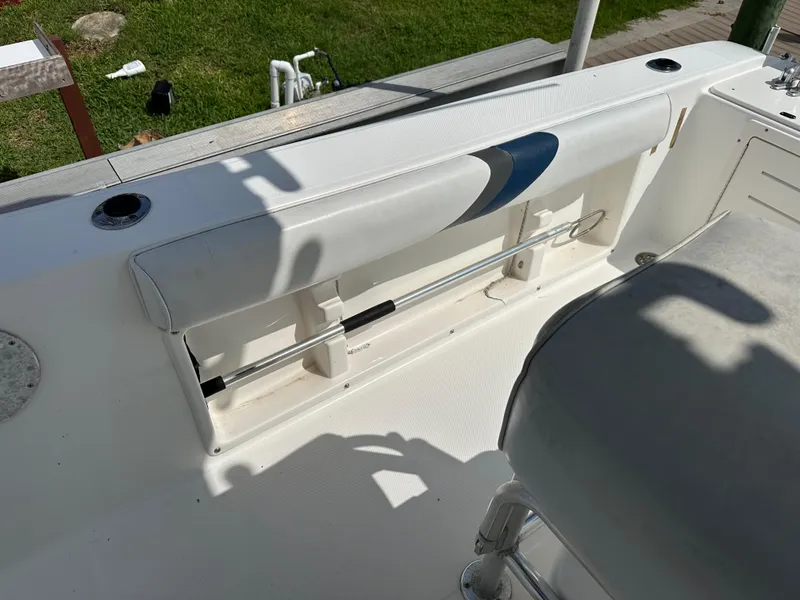 Slide: The Image of 2003 Cobia 254 Center Console boat interior with seating and rod holders. - 13