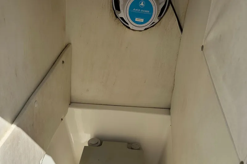 Slide: The Image of 2003 Cobia 254 Center Console interior with marine speaker and storage compartment. - 15