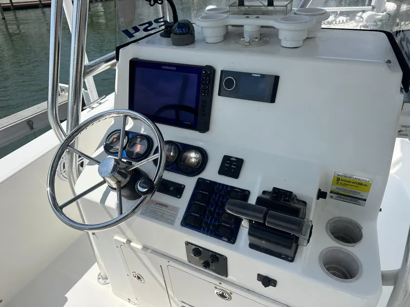 Slide: The Image of 2003 Cobia 254 Center Console boat dashboard with steering wheel and navigation equipment. - 3