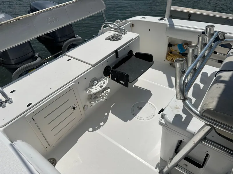 Slide: The Image of 2003 Cobia 254 Center Console boat interior with twin Yamaha engines, rod holders, and storage compartments. - 4