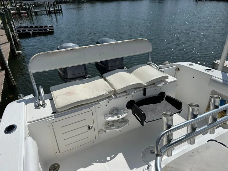 Slide: The Image of 2003 Cobia 254 Center Console boat with twin Yamaha engines, docked by the water. - 5