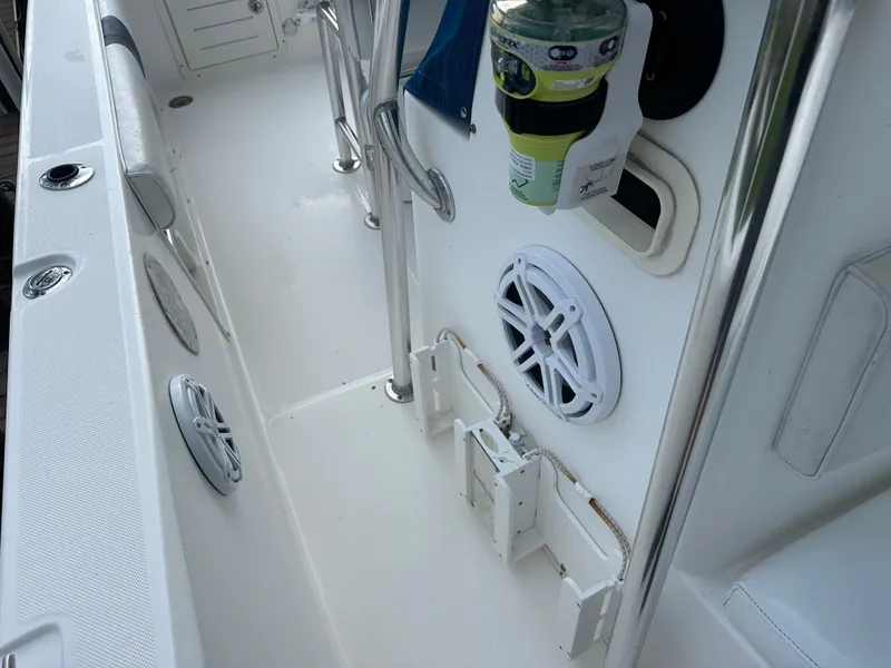 Slide: The Image of 2003 Cobia 254 Center Console interior with speakers and rod holders. - 8