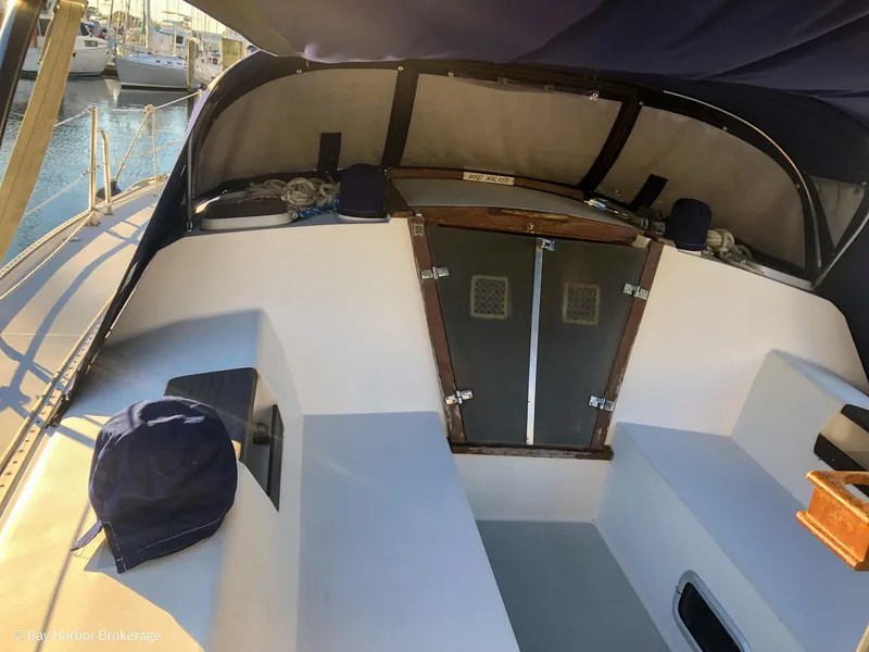 Slide: The Image of 1992 Catalina 42 sailboat cockpit with seating and hatch, docked at marina. - 12