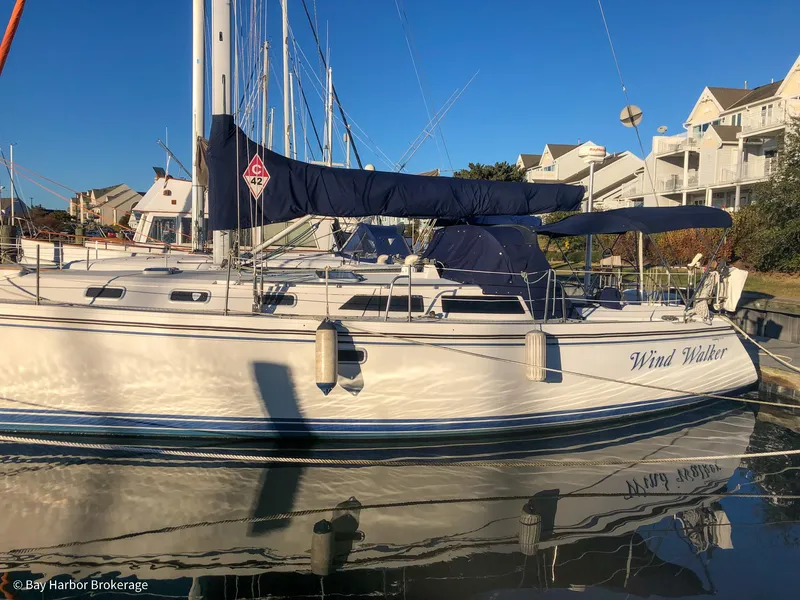 Slide: The Image of Catalina 42 sailboat from 1992 docked in a marina, reflecting on calm water. - 2