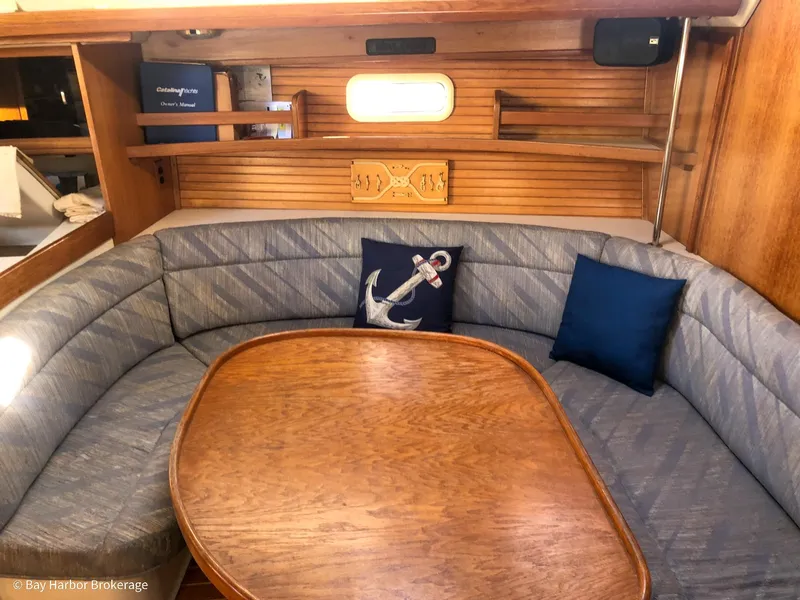 Slide: The Image of Cozy interior of 1992 Catalina 42 sailboat with cushioned seating and wooden table. - 22