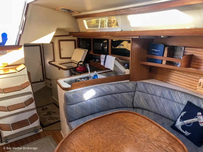 Slide: The Image of Interior of 1992 Catalina 42 sailboat with cozy seating and compact kitchen area. - 25