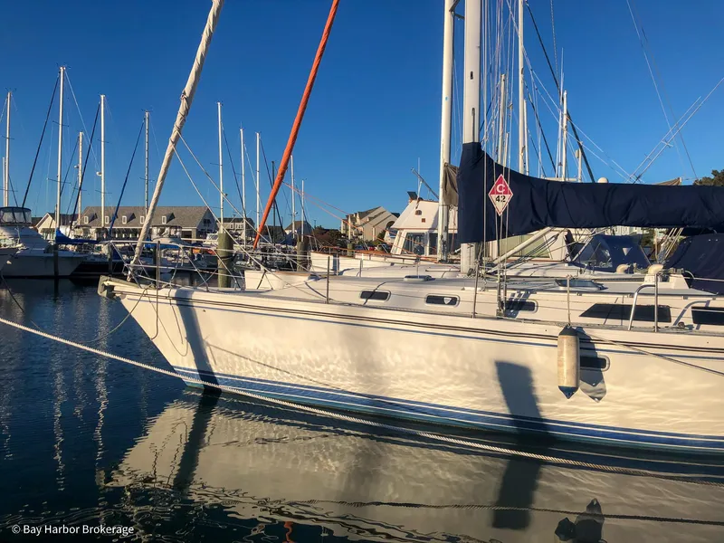 Slide: The Image of Sailboat Catalina 42, 1992 model, docked in a marina under clear blue skies. - 3