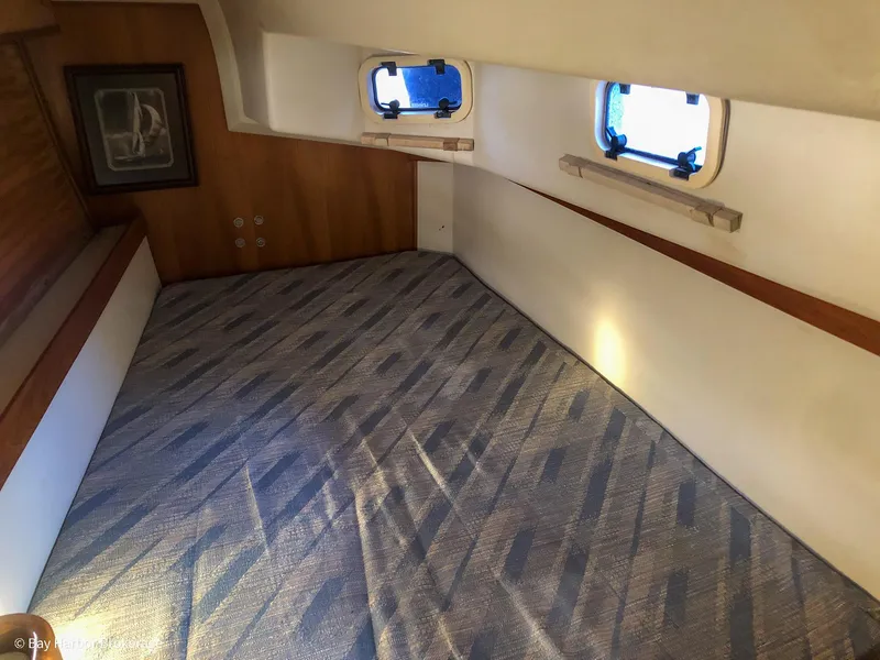 Slide: The Image of Interior cabin of a 1992 Catalina 42 sailboat with patterned bedding and portholes. - 35