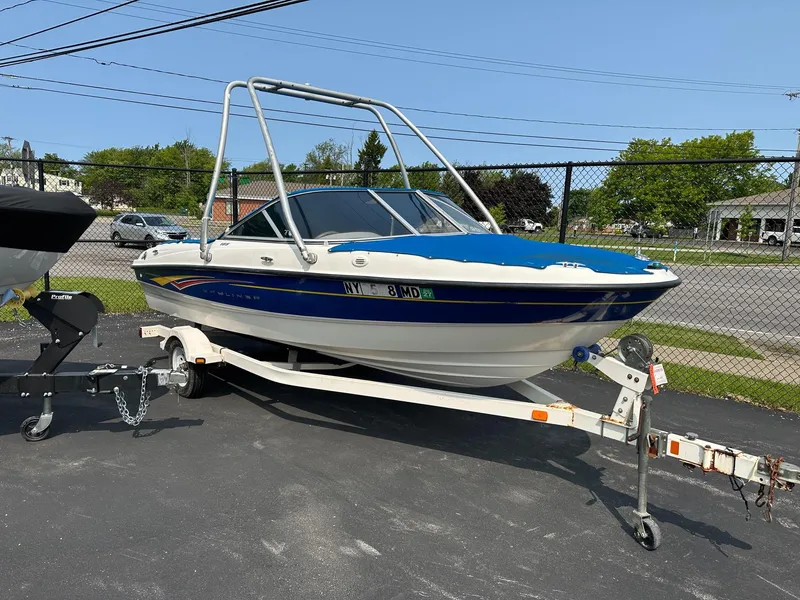The Image of 2007 Bayliner 185 Bowrider boat on trailer, parked outdoors on a sunny day. - 1
