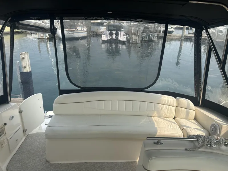 Slide: The Image of 2002 Rinker 342 Fiesta Vee boat interior with white seating, docked at marina. - 5