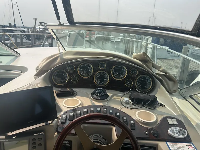 Slide: The Image of 2002 Rinker 342 Fiesta Vee boat dashboard with gauges and controls at a marina. - 7