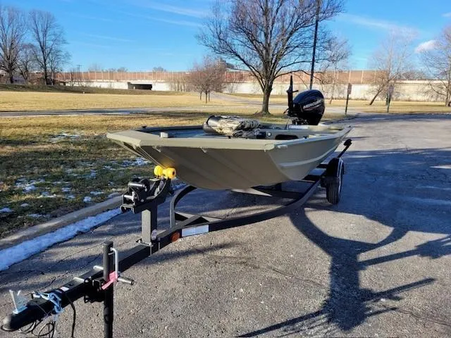 The Image of 2025 Tracker Grizzly 1654 T Sportsman boat on trailer in a park setting. - 0