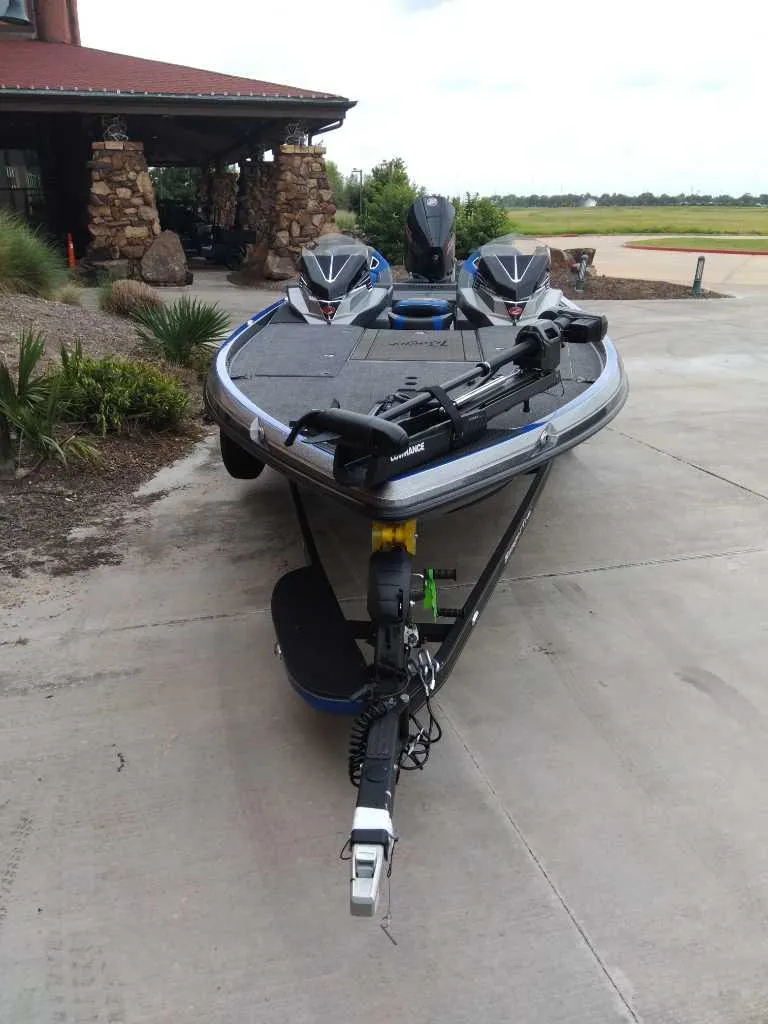 Slide: The Image of 2025 Ranger Z521R boat parked on concrete driveway near a rustic building. - 2