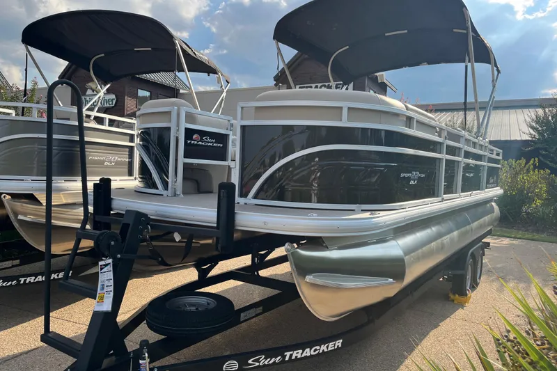 The Image of 2025 Sun Tracker SportFish 22 DLX pontoon boat on trailer, outdoor display. - 0