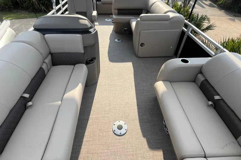 Slide: The Image of 2025 Sun Tracker SportFish 22 DLX pontoon boat interior with beige seating and spacious layout. - 5