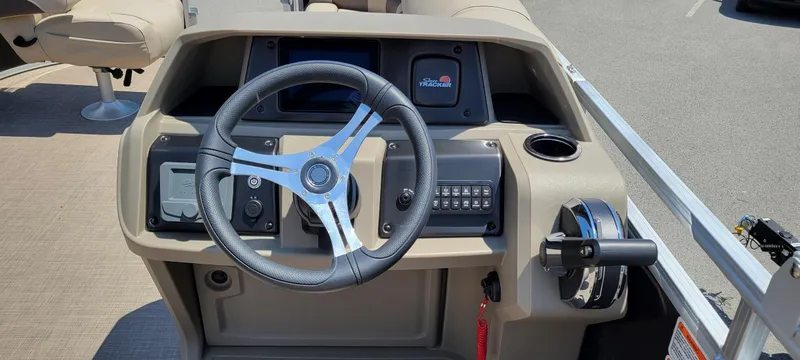 Slide: The Image of 2025 Sun Tracker SportFish 20 DLX boat dashboard with steering wheel and controls. - 3