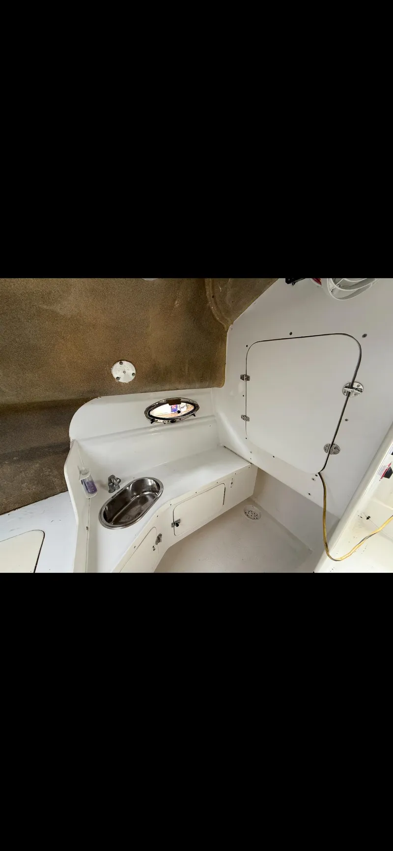 Slide: The Image of 2000 Powercat Catamaran interior with sink and storage compartment. - 11