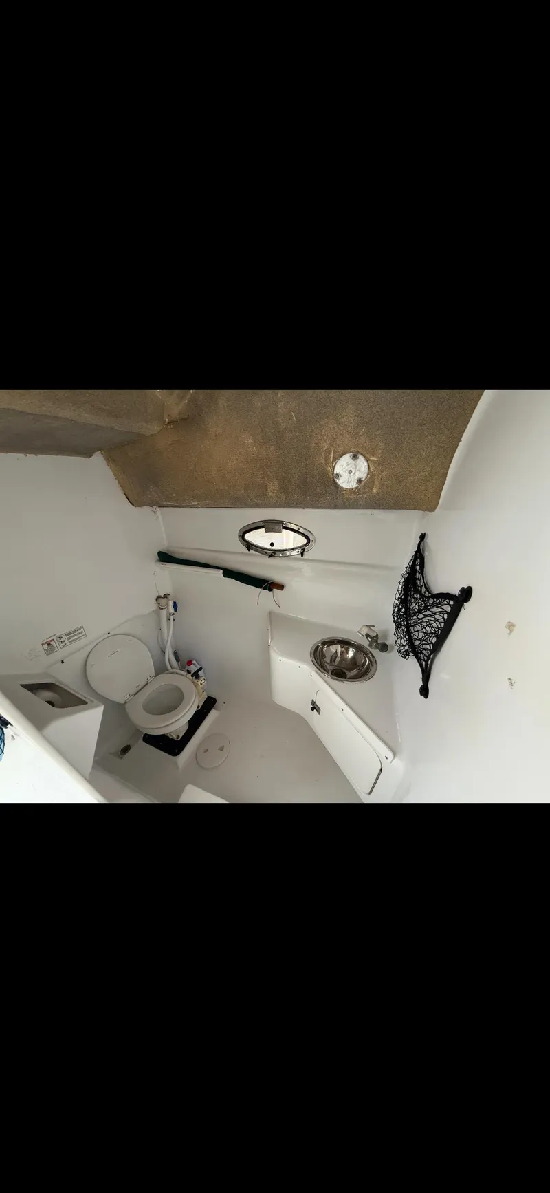Slide: The Image of 2000 Powercat Catamaran bathroom interior with toilet, sink, and storage net. - 12