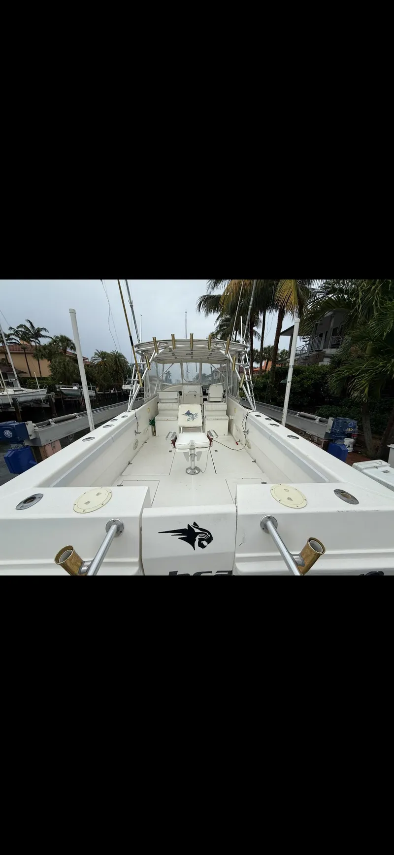 Slide: The Image of 2000 Powercat Catamaran with spacious deck and seating, docked near palm trees. - 8