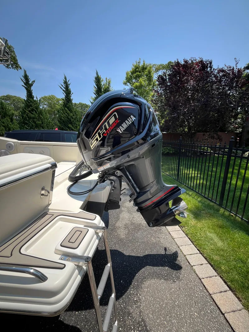 Slide: The Image of 2023 Scout 235 Sportfish boat with Yamaha outboard motor, parked outdoors. - 10