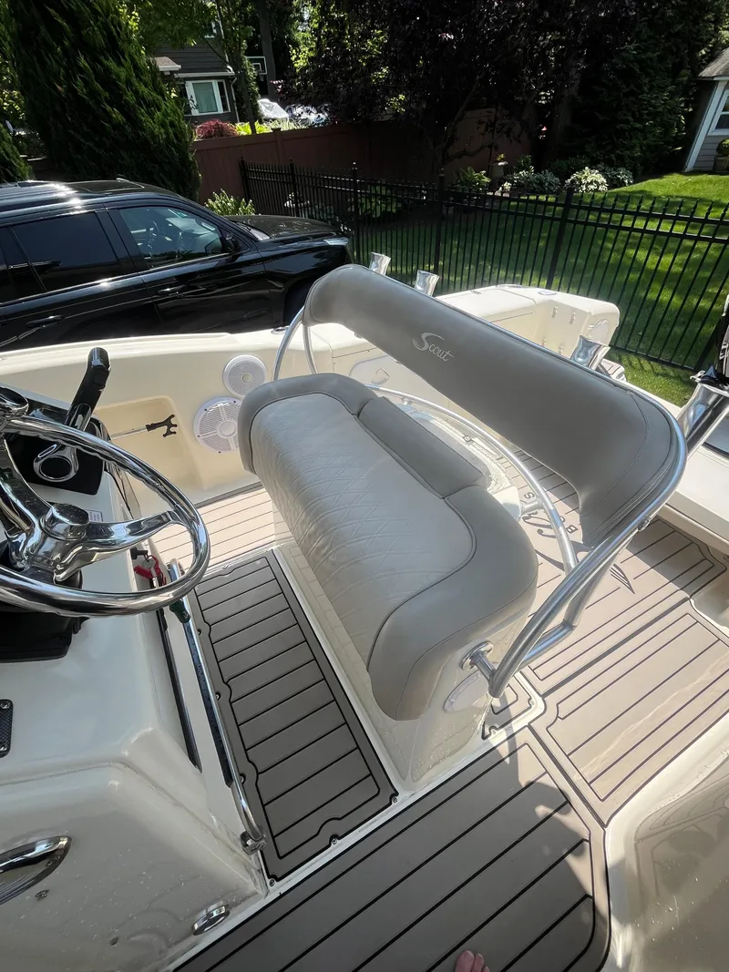 Slide: The Image of 2023 Scout 235 Sportfish boat interior with cushioned seating and steering wheel. - 11