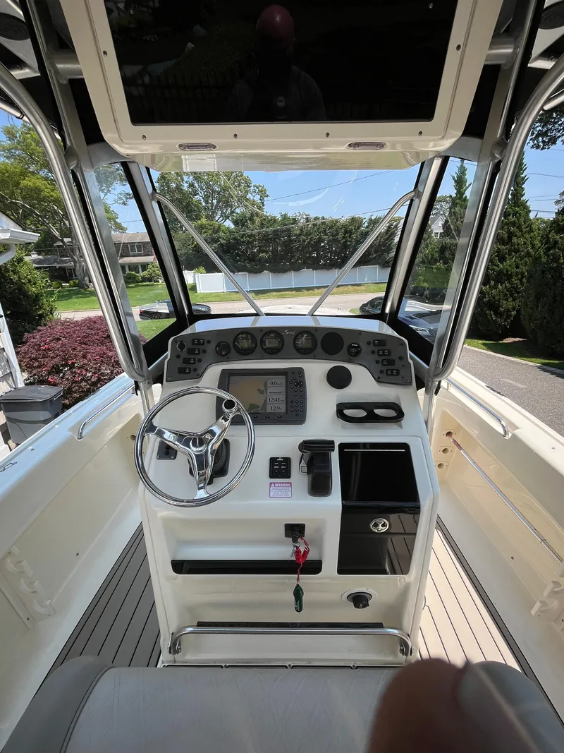 Slide: The Image of 2023 Scout 235 Sportfish boat cockpit with steering wheel and control panel. - 12