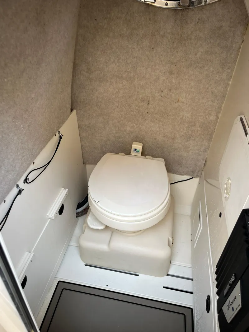 Slide: The Image of 2023 Scout 235 Sportfish boat interior with compact marine toilet. - 13