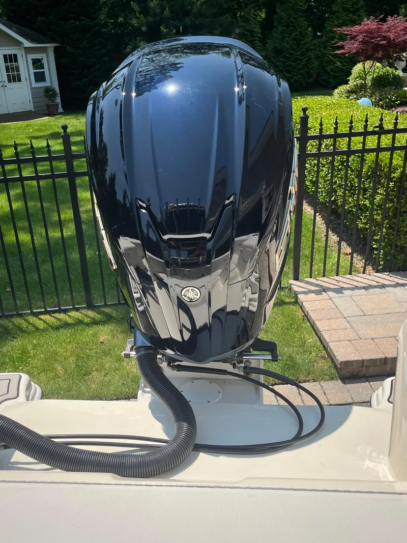 Slide: The Image of 2023 Scout 235 Sportfish boat engine in a sunny backyard setting. - 18
