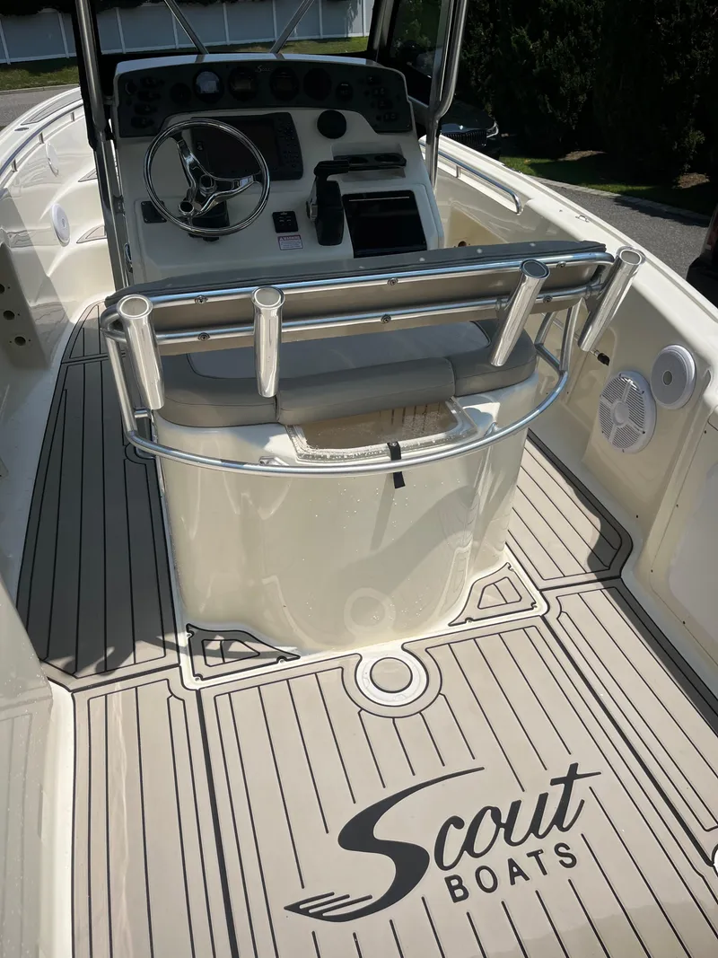 Slide: The Image of 2023 Scout 235 Sportfish boat interior with steering console and branded flooring. - 19