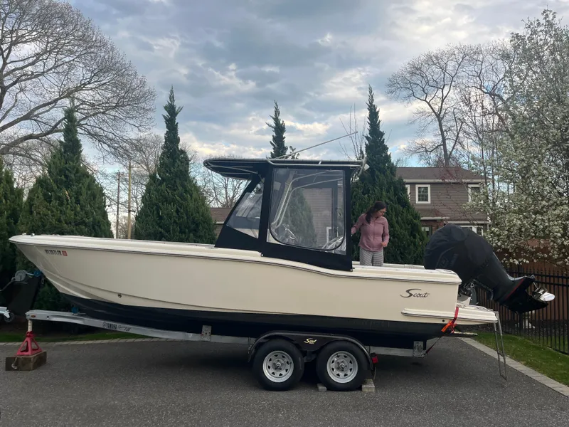 Slide: The Image of 2005 Scout 235 Sportfish boat with Yamaha engine, parked outdoors under a blue sky. - 2