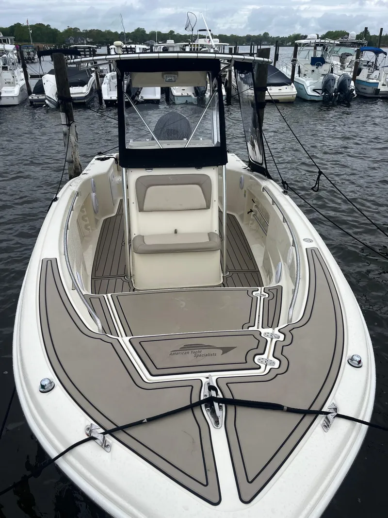 Slide: The Image of 2005 Scout 235 Sportfish boat docked at marina, featuring spacious deck and seating. - 5