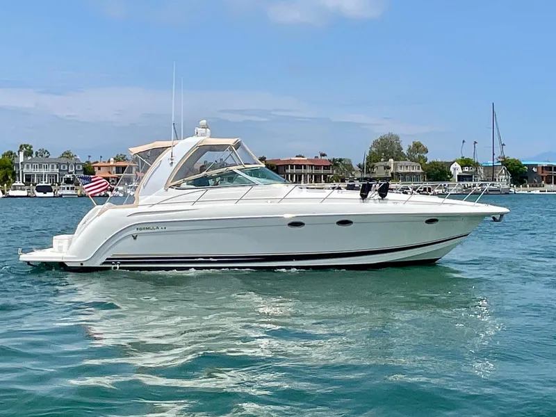 Slide: The Image of 2003 Formula 40 PC yacht cruising on a sunny day near waterfront homes. - 0