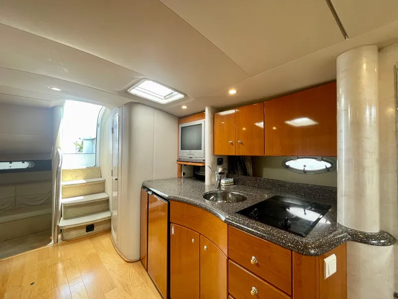 Slide: The Image of 2003 Formula 40 PC yacht interior with modern kitchen, wood cabinetry, and stairs leading to deck. - 18