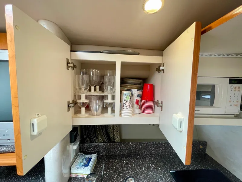 Slide: The Image of Open kitchen cabinet with glasses and cups in a 2003 Formula 40 PC boat. - 20