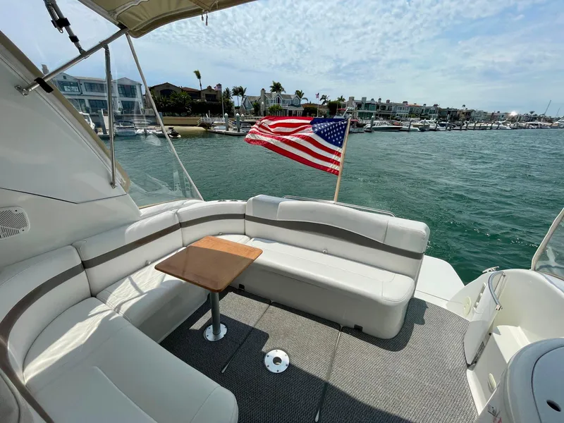 Slide: The Image of 2003 Formula 40 PC yacht with seating area, table, and American flag on a sunny day. - 44