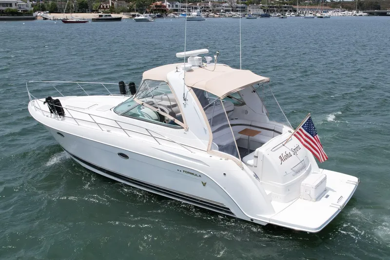 Slide: The Image of 2003 Formula 40 PC yacht cruising on water with American flag, marina in background. - 5