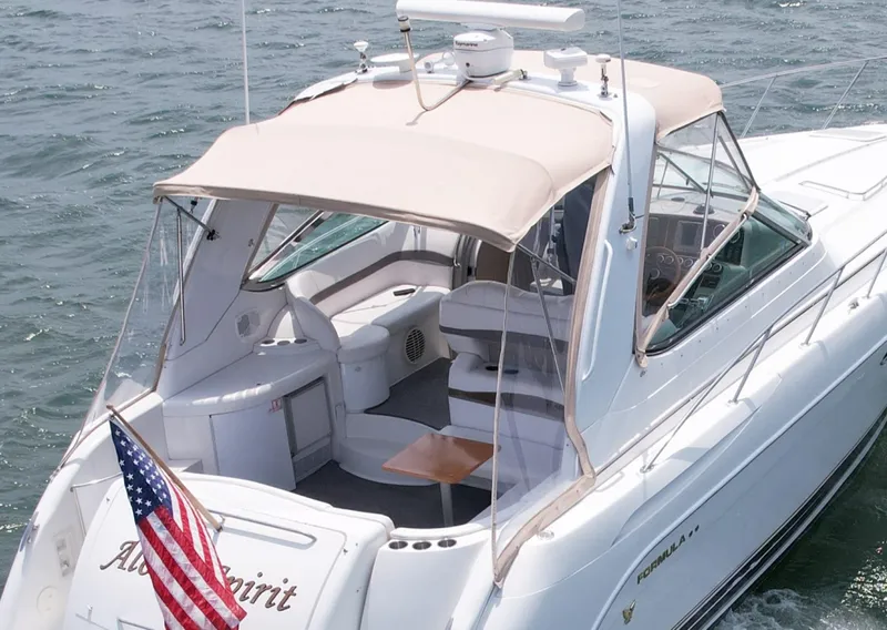 Slide: The Image of 2003 Formula 40 PC yacht with canopy, American flag, and spacious deck on the water. - 9