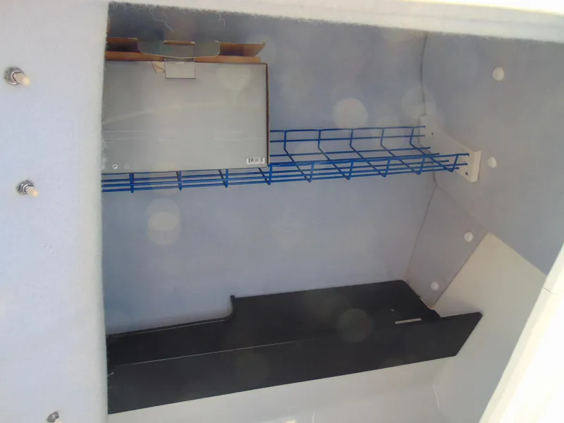 Slide: The Image of Storage compartment inside a 2020 Yamaha Boats AR240, featuring shelving and wiring. - 11